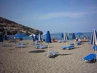 Het strand in het dorp Matala, in de verte het eiland Nisia Paximadia.